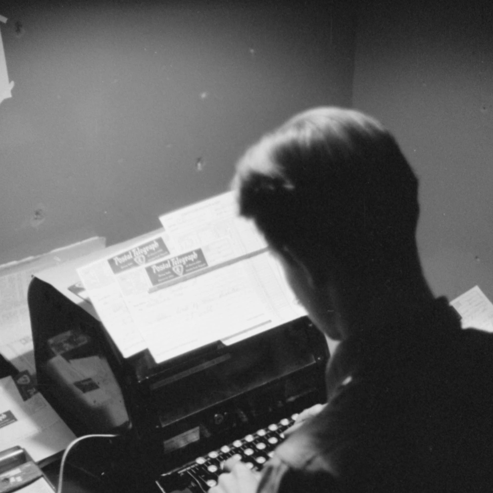 Picture of a person typing on a typewriter.